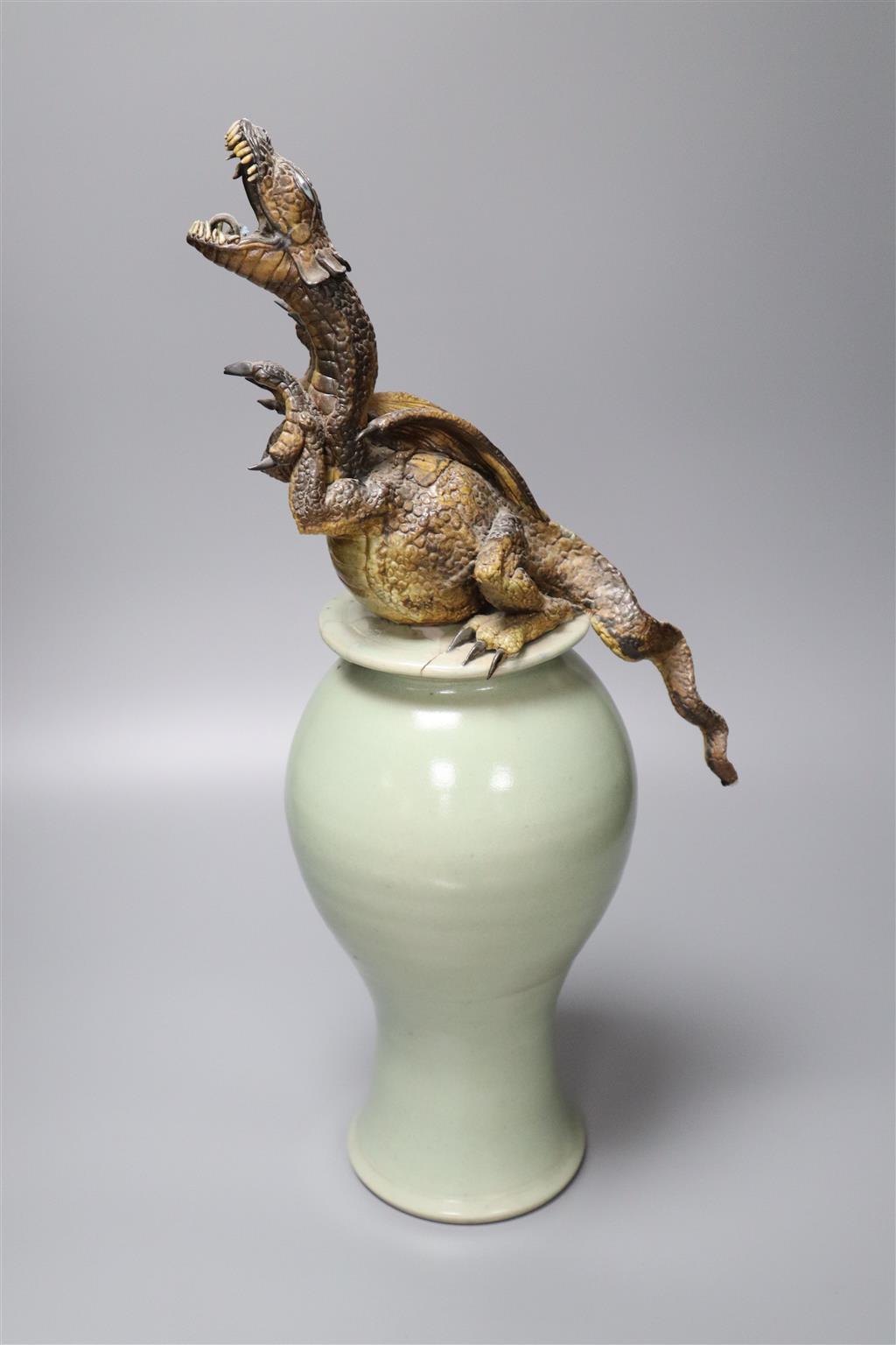 A Chinese celadon vase and cover having later cold-painted metal dragon terminal (repair)